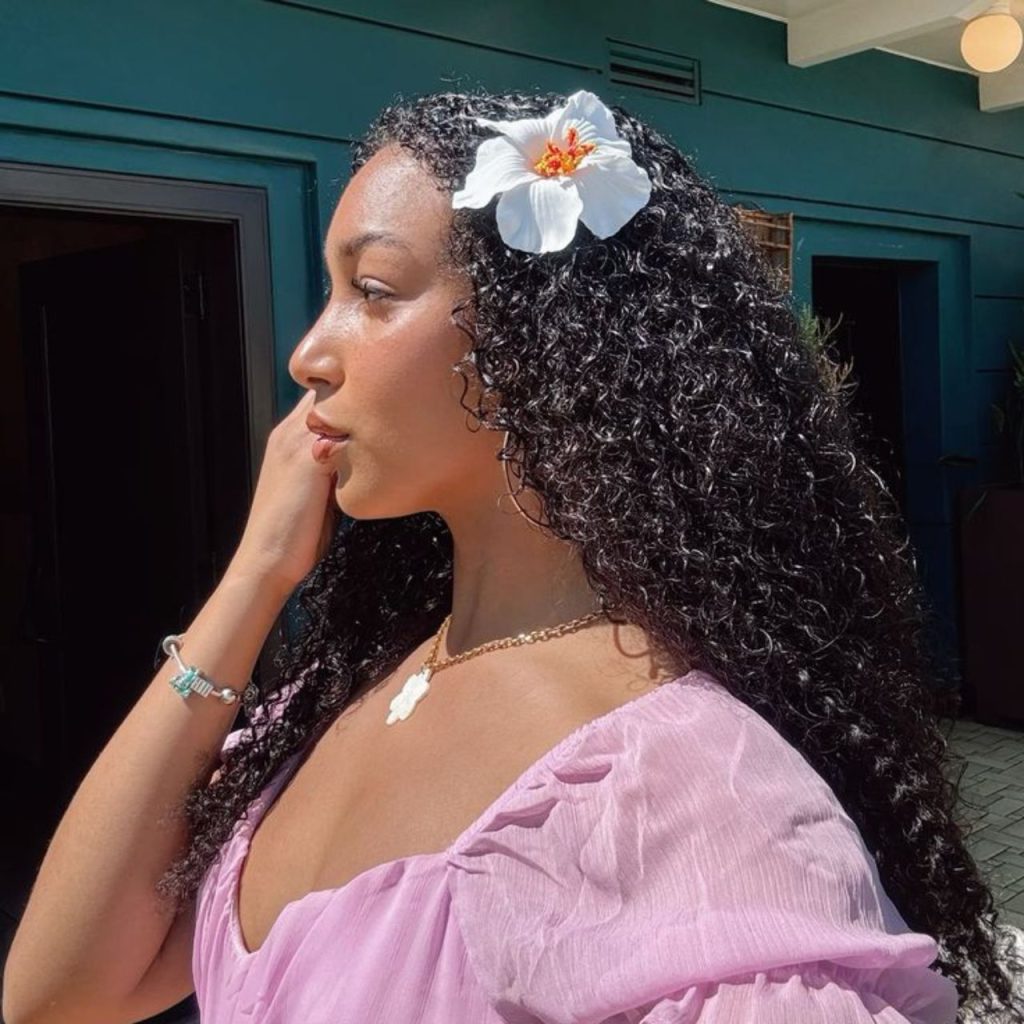 Curly Hawaiian Hairstyle with white flower in the hair