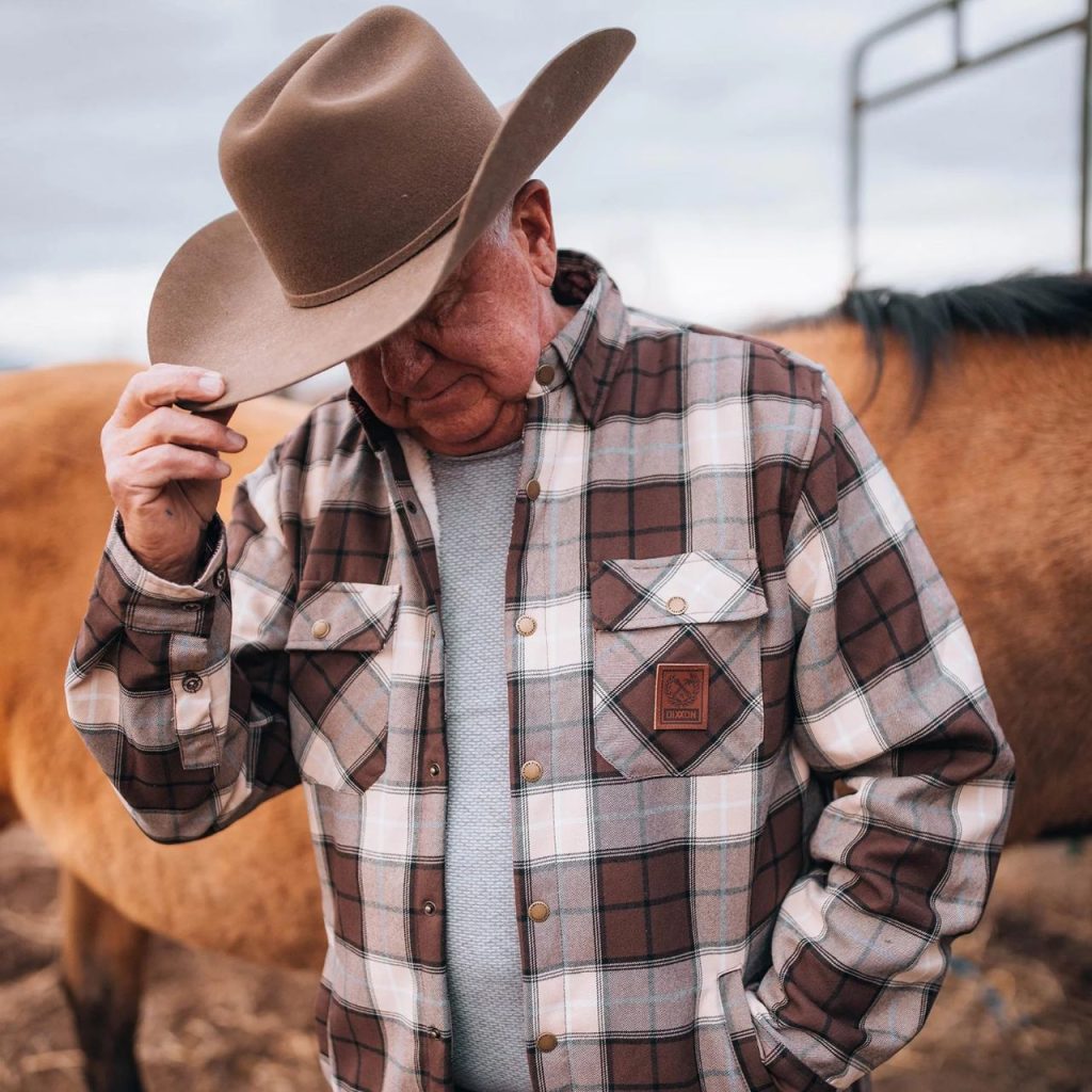Old Man wearing White and brown checkered Dixxon Flannel Jacket with hat