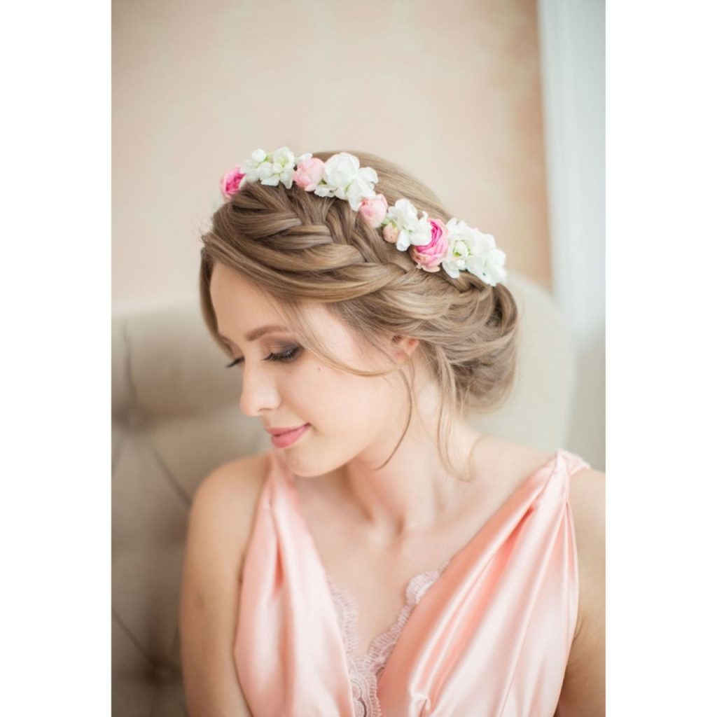 Half-up braid Hawaiian Hairstyle wearing white and pink flowers on the head